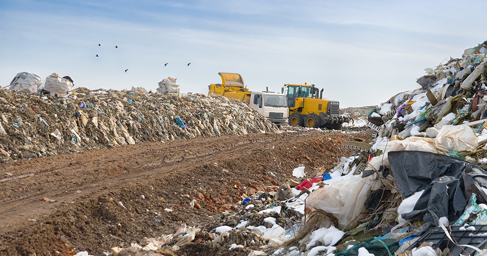 A photo of a truck moving waste at a landfill site