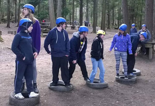 People wearing helmets and balancing on tyres