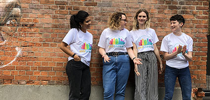 Photo of people leaning against a wall wearing t-shirts with the Clean Air Day logo on