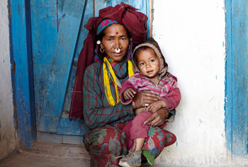 Photo of an adult holding a child sat in a doorway