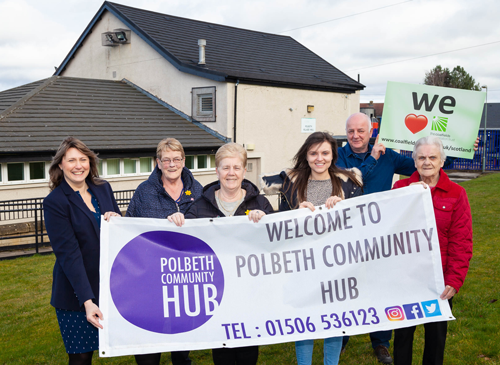 Photo of people holding a banner that reads "Welcome to Polbeth community hub"