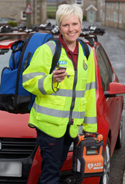 Photo of a community first responder in their hi-vis uniform with their equipment in a bag on their back
